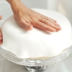 Placing and stretching fondant icing to cover all the cake at our Cake decorating courses