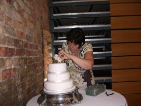 A picture our cake designer setting up a wedding cake at a local wedding venue.