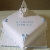 blue and white christening cake with baby in crib