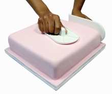  Smoothing fondant on cake to give good finish from our sugarcraft classes